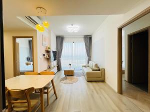 a living room with a table and a couch at May Homes - Masterise Centre Point Vinhomes Grand Park in Long Bình