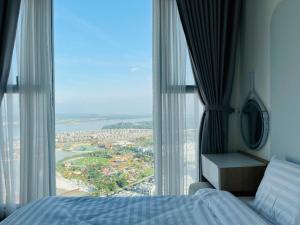 a bedroom with a bed and a large window at May Homes - Masterise Centre Point Vinhomes Grand Park in Long Bình
