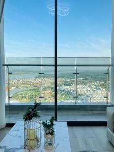 a room with a view of a city from a large window at May Homes - Masterise Centre Point Vinhomes Grand Park in Long Bình