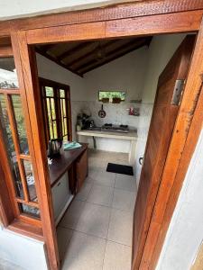 an open door to a kitchen with a counter at Ubud Leke-Leke Guesthouse - Rumah Kayu in Gianyar