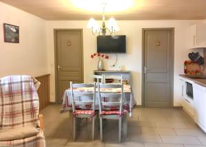 a kitchen with a table with chairs and a tv at Appartement confortable à Cornimont 30 m² vue montagne in Cornimont +5 photos
