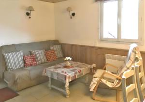 a living room with a couch and a table at Appartement confortable à Cornimont 30 m² vue montagne in Cornimont