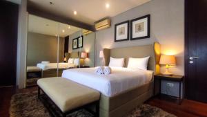 a bedroom with a large bed and a mirror at Apartment 3BR with River View in City Center at Sumatra36 Surabaya By Travelio in Surabaya +23 photos