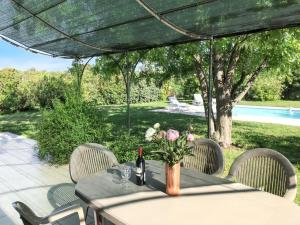 Una mesa con una botella de vino y flores encima. en Villa reposante à Solaro avec piscine privée et jardin, en Solaro