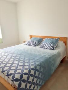 a bed with blue and white sheets and pillows at Villa avec piscine privée à Saint-Jean-de-Monts in Saint-Jean-de-Monts +52 photos