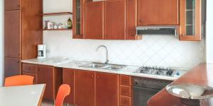 een keuken met houten kasten en een spoelbak bij Comfortable apartment in Marsala with balcony and parking in Marsala +10 foto's