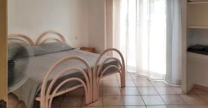een slaapkamer met een bed met stoelen naast een raam bij Comfortable apartment in Marsala with balcony and parking in Marsala