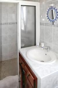 a bathroom with a white sink and a mirror at Superbe appartement à Petite Île avec vue mer et montagne. in Petite Île