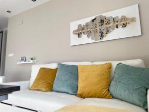 a white couch with colorful pillows in a living room at HOUSE LOVE TERRAZA PREMIUM 1 DORMITORiO 6PX in Sierra Nevada