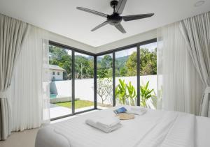 a bedroom with a white bed and a large window at Villa Amour 3 Bedroom Spa Pool Retreat near Beach - Lamai in Amphoe Koh Samui +27 photos