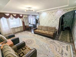 a living room with a couch and a table at 3-х комнатная квартира район магазин Радуга in Kostanay