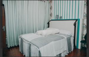 a bed with two pillows on it in a room at Ratu Homestay in Tanjungkarang