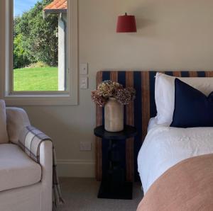 ein Schlafzimmer mit einem Bett und einer Couch und einem Fenster in der Unterkunft Ocean Beach Residence in Tuki Tuki