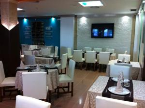 a dining room with tables and white chairs and a unintention at El Torreon del Miguelete in Miguel Esteban