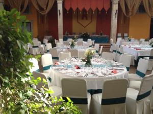 un salón de banquetes con mesas blancas y sillas blancas en El Torreon del Miguelete, en Miguel Esteban