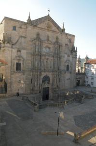 una antigua iglesia de piedra con un gran edificio en Pensión Da Estrela, en Santiago de Compostela
