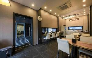a dining room with a table and white chairs at Best In City Hotel in Daejeon