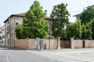 una calle vacía con una pared de ladrillo y árboles en Palazzo Raspanti, en Treviso