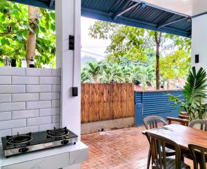 an outdoor patio with a stove and a table at Full House in El Nido