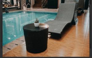 a pool with a table and a chair and a plant at Ratu Homestay in Tanjungkarang +1 photo