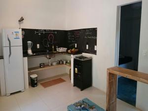 a kitchen with a blackboard on the wall and a refrigerator at Vila Engawa Flats in Itacaré