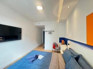 a living room with a bed and a tv at X - The Subiaco - Edumetro Subang Jaya in Subang Jaya