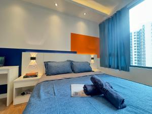 a bedroom with a large bed with a blue blanket at X - The Subiaco - Edumetro Subang Jaya in Subang Jaya