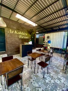 ein Restaurant mit Tischen und Stühlen und ein Schild an der Wand in der Unterkunft แอทเกาะล้านรีสอร์ท in Ko Sak