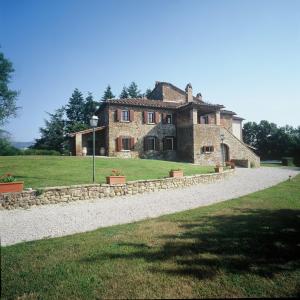 an old stone house on a field with a gravel driveway at Agriturismo Sant'illuminato in Calzolaro