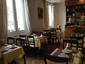 a dining room with tables and chairs and windows at Hôtel du Square d'Anvers in Paris +37 photos