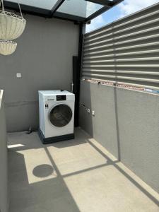 a washing machine is sitting in a laundry room at Lioravilla15 Kota Baru Parahyangan in Padalarang