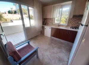 a kitchen with a chair and a sink and a tub at Karaburun'da Deniz Manzaralı Ferah Dubleks Villa in Karaburun