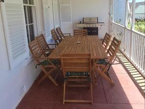 a wooden table and chairs on a porch at Red Ridge Mountain Lodge in Buffelskloof