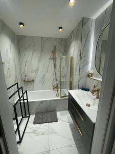 a white bathroom with a tub and a sink and a mirror at St George in Antibes