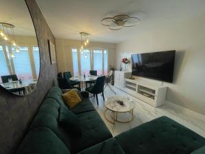 a living room with a green couch and a television at St George in Antibes
