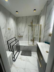 a white bathroom with a tub and a sink at St George in Antibes