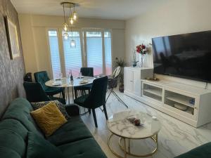 a living room with a couch and a table and a tv at St George in Antibes