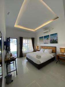 Un dormitorio con una cama grande y una ventana grande. en Sea Coral Beach Resort, en Kawal