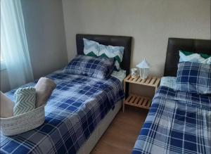 a bedroom with two twin beds and a night stand at Karaburun'da Deniz Manzaralı Ferah Dubleks Villa in Karaburun