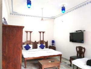 una camera con due letti e una TV a schermo piatto di Sneh Deep Guest House a Jaipur