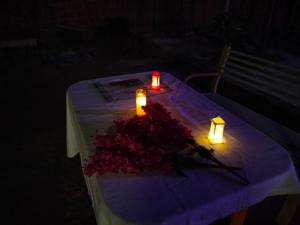 una mesa con dos velas y un ramo de flores en Alibaug Homestay by Weekend Thrills, en Alibaug
