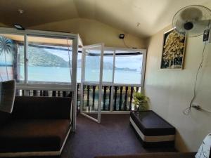 a living room with a couch and a large window at Gracias Place in El Nido +6 photos