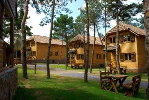 a group of wooden lodges with a picnic table and trees at Xalet De Prades in Prades