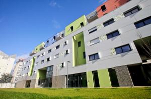 un bâtiment vert et blanc dans l'établissement Odalys City Tours Le Jardin des Lettres, à Tours