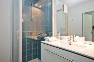 a bathroom with a sink and a shower at Appart Hotel Odalys City Tours Le Jardin des Lettres in Tours