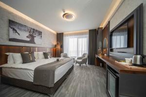a hotel room with a large bed and a desk at Peony Palace Hotel in Kayseri +84 photos