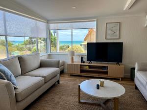 阿丁格海滩Magpie Sands - Coastal Escape & Wine Country - Beachside Getaway的配有沙发和平板电视的客厅