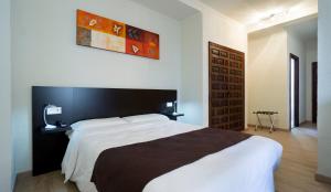 a bedroom with a large bed with a black headboard at Hotel El Pozo in Torremolinos