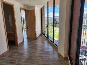 un couloir avec de grandes portes en verre et une chambre dotée de parquet. dans l'établissement Departamento Epic-Quito, à Hacienda Carolina