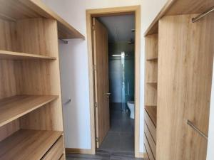 Cette chambre dispose d'étagères en bois et d'une salle de bains avec toilettes. dans l'établissement Departamento Epic-Quito, à Hacienda Carolina